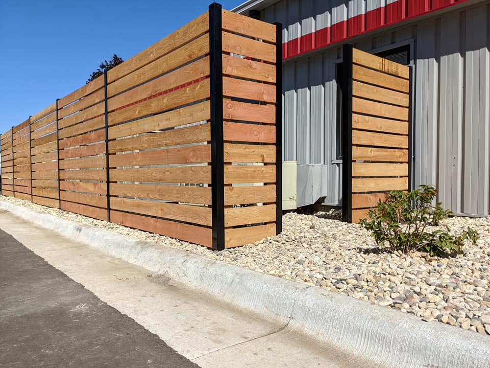 A picture of a wooden fence with steel posts.