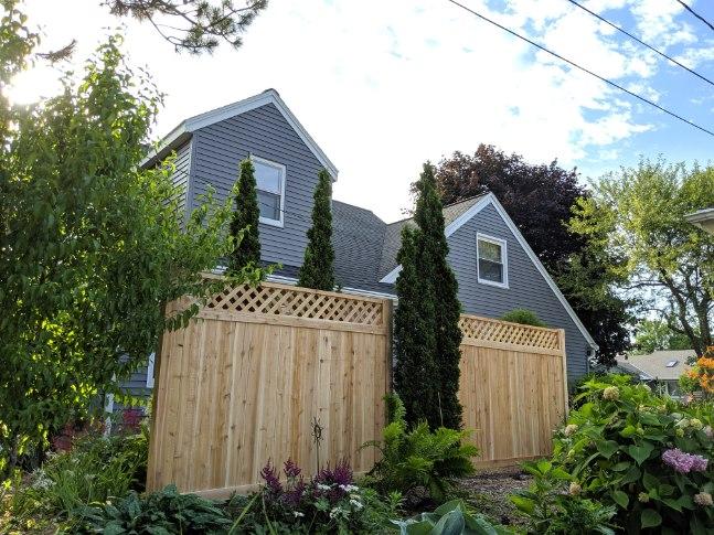 A picture of a wooden fence with alternating panel boards.